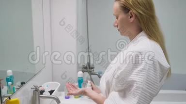 面子的关怀观念.. 女人用化妆水在浴室里照顾皮肤。 上午卫生